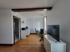 a white living room with a television and a desk at Stone House Kenora in Kenora