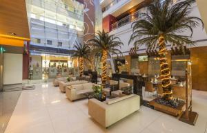 um átrio com sofás e palmeiras num centro comercial em The Regenza By Tunga em Navi Mumbai