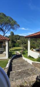 un camino de piedra que conduce a una casa con un árbol en Pousada Pedacinho do Ceu chale 2, en Cunha