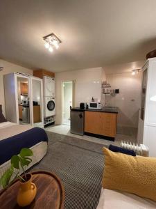 uma sala de estar com uma cama e uma cozinha em Cosy Studio with Courtyard in Vibrant Fitzroy! em Melbourne
