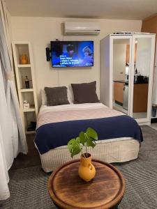 um quarto com uma cama e uma mesa com um vaso de plantas em Cosy Studio with Courtyard in Vibrant Fitzroy! em Melbourne