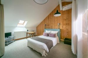 a bedroom with a large bed and a table at Maison d'hôtes Villa Richelieu in Châtellerault