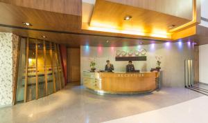 two people sitting at a reception desk in a lobby at The Regenza By Tunga in Navi Mumbai