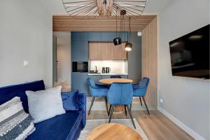 a living room with a blue couch and a table at GRANO FLATS Sobieszewo - Baltic Line in Gdańsk