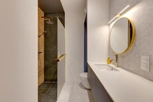 a bathroom with a shower and a sink and a mirror at GRANO FLATS Sobieszewo - Baltic Line in Gdańsk +45 photos