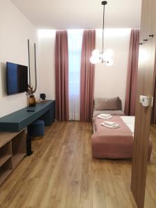 a room with a bed and a desk and a television at Lux City Apartments & Rooms in Sarajevo