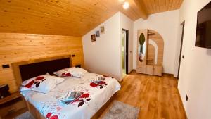 een slaapkamer met een bed in een houten kamer bij Casa dintre Brazi in Statjunea Borsa