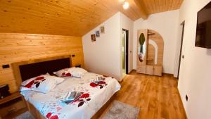a bedroom with a bed in a wooden room at Casa dintre Brazi in Statjunea Borsa