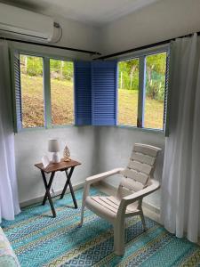 una silla y una mesa en una habitación con ventanas en Massalli Sanctuary Lodge, en San Andrés