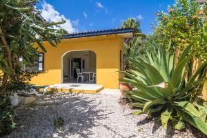 żółty dom z patio i roślinami w obiekcie 28 Casa Ruby w mieście Kralendijk