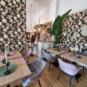 a restaurant with wooden tables and chairs and flowers on the wall at Oaza Resort in Stegna