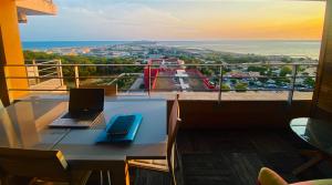 a laptop computer sitting on a table on a balcony at #Sète T3 Vue mer & étang Piscine Balcon in Sète