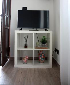 a white entertainment center with a television on it at [Stazione] - Casa privata con veranda in Romano di Lombardia