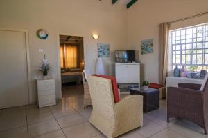 un salon avec des chaises, un canapé et une table dans l'établissement 28B Casa Kokolishi, à Kralendijk