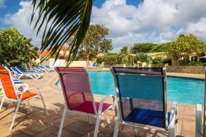 un groupe de chaises assises à côté d'une piscine dans l'établissement 28B Casa Kokolishi, à Kralendijk 6 autres photos