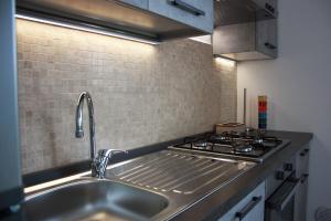 a kitchen with a sink and a stove at [Stazione] - Casa privata con veranda in Romano di Lombardia