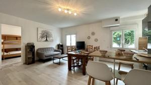 a living room with a table and chairs and a couch at L'Appart de nos 2 vies in Le Crotoy