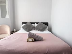 a bed with a pink blanket and a pillow on it at Budget 1 Bedroom Flat Inner-City Value in Cardiff