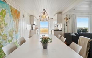 ein Esszimmer mit einem weißen Tisch und einer Vase aus Blumen in der Unterkunft Beautiful Home In Ebeltoft With House Sea View in Ebeltoft