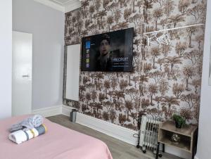 a bedroom with a tv on a wall at Budget 1 Bedroom Flat Inner-City Value in Cardiff