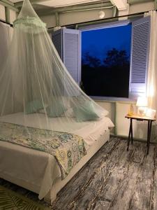 a bedroom with a bed with a mosquito net at Massalli Sanctuary Lodge in San Andrés