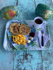 a plate with breakfast food and a cup of coffee at Massalli Sanctuary Lodge in San Andrés
