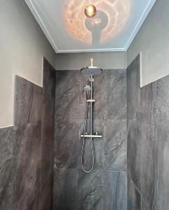 a shower in a bathroom with a ceiling at De Kamperveste in Kampen