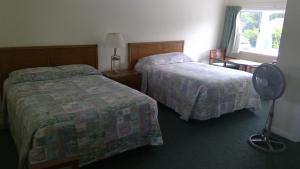 Ένα ή περισσότερα κρεβάτια σε δωμάτιο στο VILLAGE GREEN MOTEL