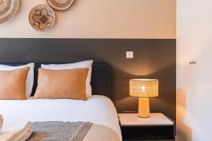 une chambre avec un lit et une lampe sur une table dans l'établissement Liberdade Elegance W/Rooftop Pool by LovelyStay, à Lisbonne 40 autres photos