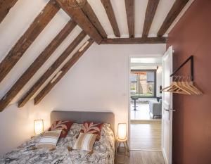 - une chambre avec un lit dans une pièce dotée de plafonds en bois dans l'établissement Le Rooftop - vue Cathédrale - Climatisation, à Troyes