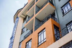 a building with balconies on the side of it at Jay Homes - Modern & Cozy Apartments PGS Plaza - Nakuru CBD in Nakuru