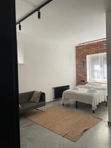 a living room with a white table and a chair at Apartament LOFT in Ostróda