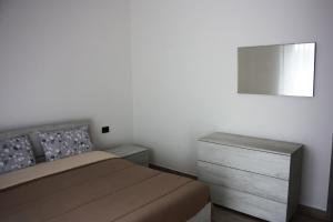 a bedroom with a bed and a dresser and a mirror at [Stazione] - Casa privata con veranda in Romano di Lombardia