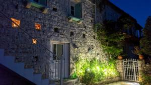 a stone house with a white door at night at Cosy Studio with breathtaking view in Gaios