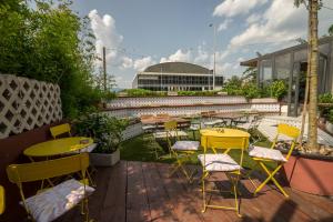 a patio with yellow tables and chairs and a building at Lemon Market rooms in Zagreb