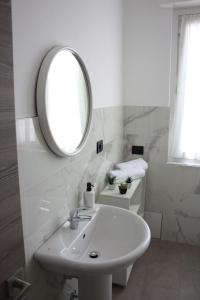 a white bathroom with a sink and a mirror at [Stazione] - Casa privata con veranda in Romano di Lombardia