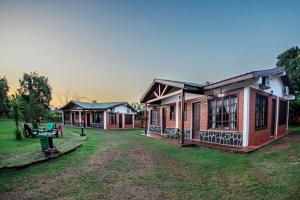 un grupo de edificios con un patio delante de ellos en Cabañas El Refugio del Mensu en Puerto Iguazú