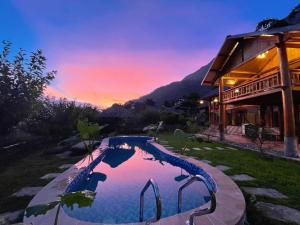 薩帕的住宿－Moc Home Sapa，一座游泳池,位于一座享有日落美景的房屋前