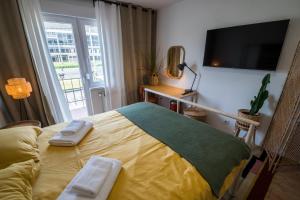 1 dormitorio con 1 cama, TV y ventana en Lemon Market rooms, en Zagreb