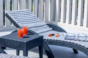 two glasses of orange juice sitting on a chair at Apartments Seafront in Pupnat