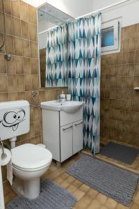 a bathroom with a toilet and a sink and a shower at Apartments Seafront in Pupnat