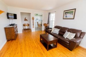 a living room with a brown leather couch and a table at Cache Rapids Vacation Rental in Reidville