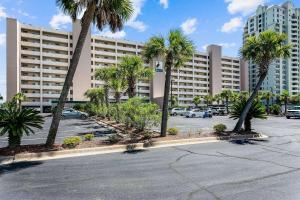a parking lot with palm trees in front of a large building at Regency Condo 405 in Navarre