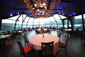 a dining room with tables and chairs and a chandelier at Utsjoki Arctic Resort in Utsjoki