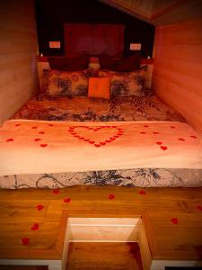 - un lit avec des roses au sol dans une chambre dans l'établissement La Tiny Blue - maison insolite pour 2 - sans Tv, à Saint-Aignan