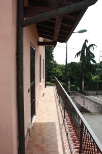 a walkway next to a building with a fence at [Stazione] - Casa privata con veranda in Romano di Lombardia