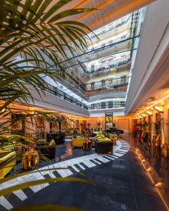 a lobby with a palm tree in a building at Aria Hotel Budapest by Library Hotel Collection in Budapest