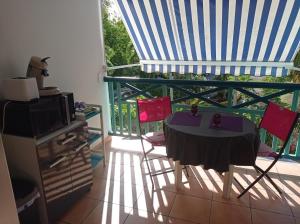 a room with a table and chairs on a balcony at Studio Mahogany in Sainte-Anne