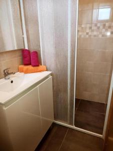 La salle de bains est pourvue d'une douche et d'un lavabo blanc. dans l'établissement Valle Verde, à Vinkuran