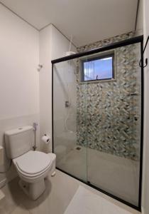 y baño con aseo y ducha acristalada. en Casa dos Lírios, en Alto Paraíso de Goiás